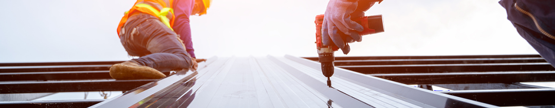 Image of roofer worker in protective uniform wear and gloves, concept of residential building under construction.